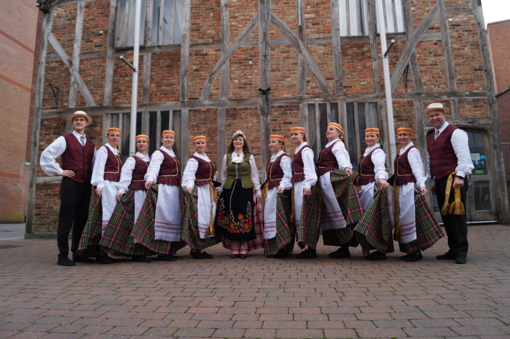 Portrait by Bartosz Fedkowicz of a community group in traditional dress outside a historic building in Boston Lincolnshire