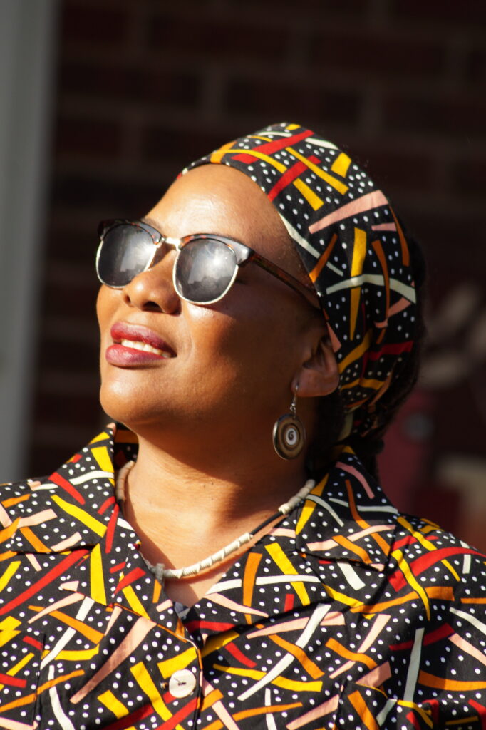 Portrait by Bartosz Fedkowicz of a Boston resident wearing patterned clothing and sunglasses, featured in Kaleidoscope exhibition