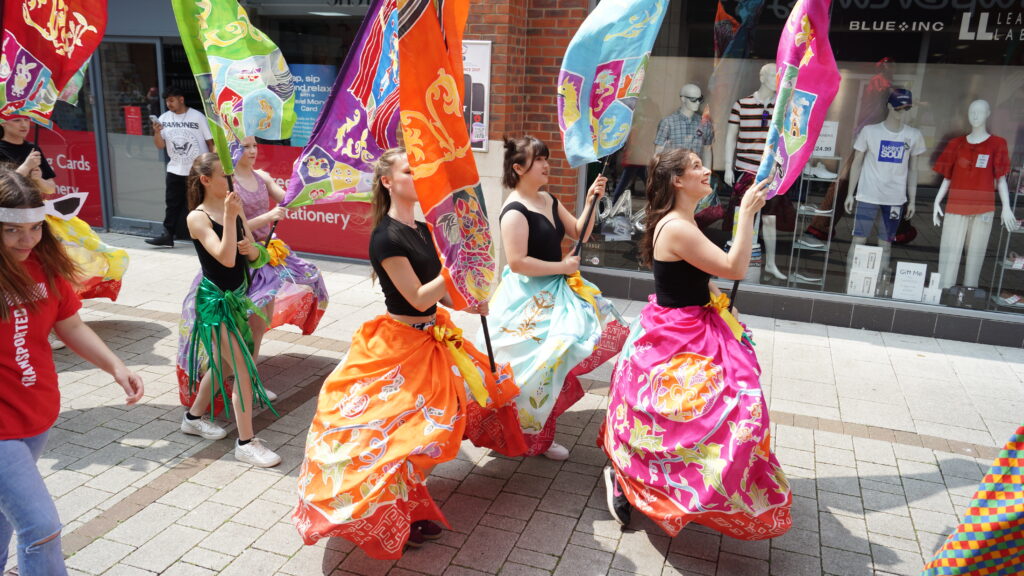 Colourful silk-painted heritage themed banners are paraded through Boston by dancers