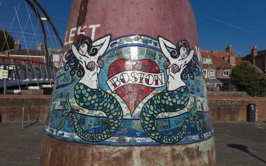 Mosaic artwork of two mermaids, inspired by the town crest, and a heart reading Boston by Carrie Reichardt on one of the Boston Buoys sculptures in Boston Lincolnshire