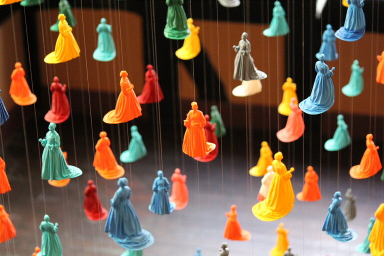 Colourful suspended 3D figures in Pilgrim Woman Assembly installation at Shodfriars Hall Boston