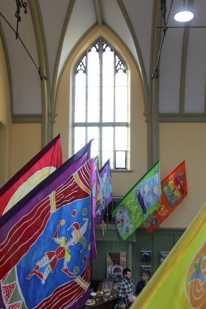 Colourful silk-painted heritage themed banners hang from the balcony of the Great Hall in Shodfriars, Boston