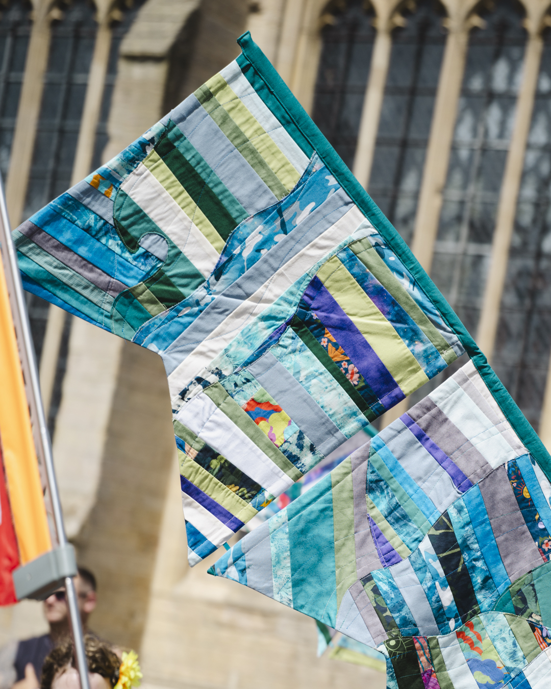 Detailed quilted Hanse banner with blue and green patchwork design displayed outside historic building in Boston Lincolnshire