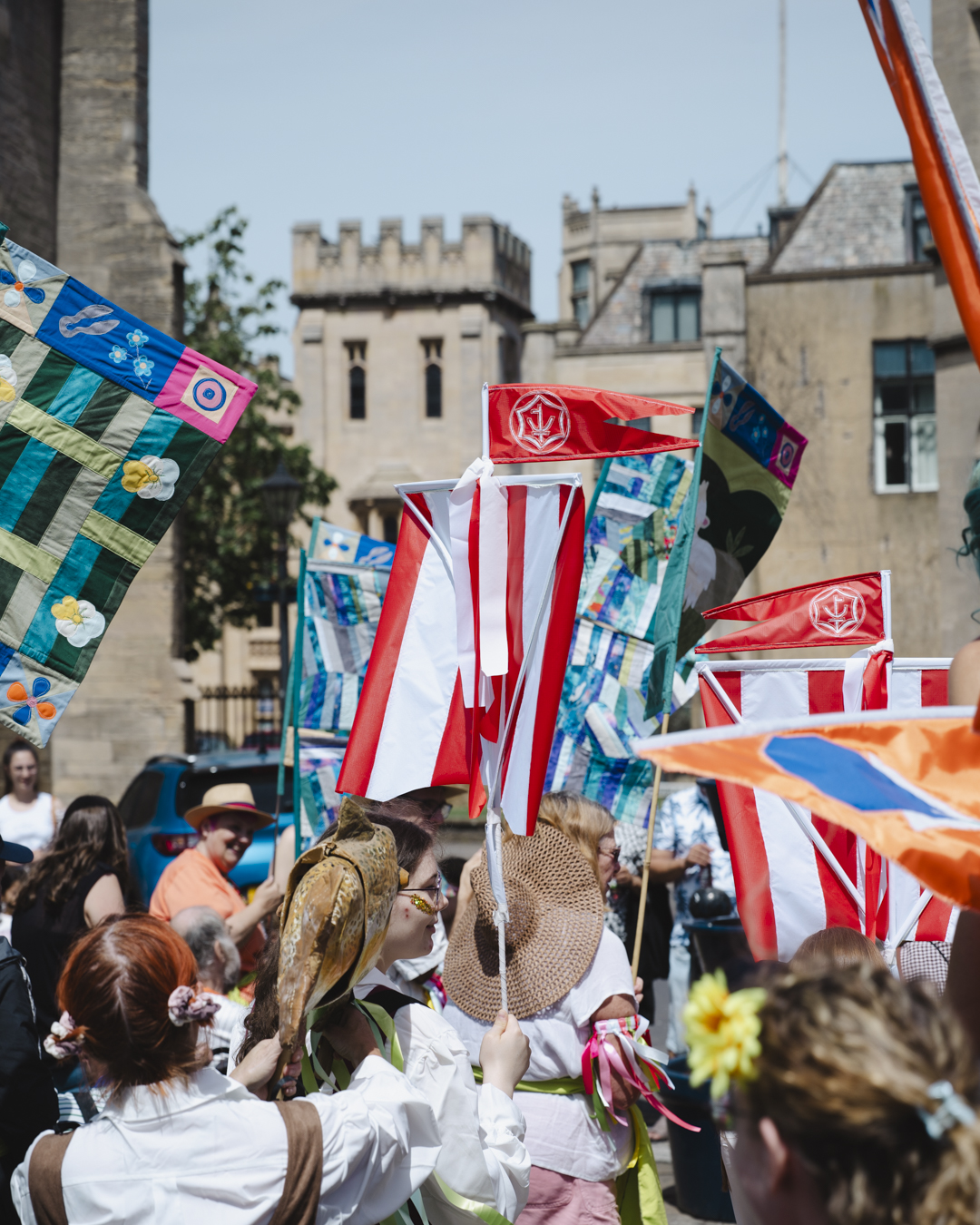 Boston Hanseatic Day parade with participants wearing Hansekoggen boat costumes and carrying red and white ship sails through the town centre