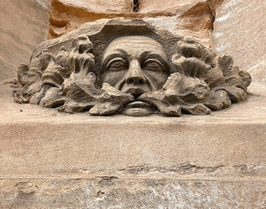 Gargoyle of a human face carved in stone on the Boston stump