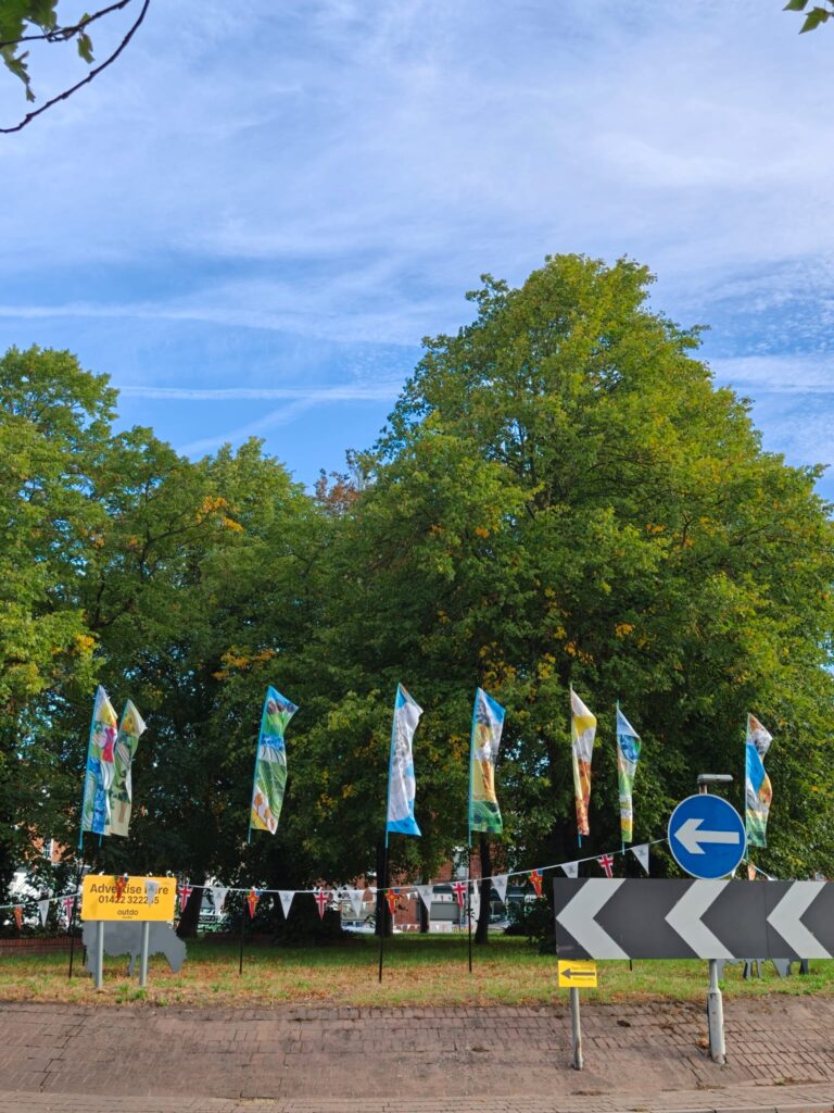 8 colourful feather flags can be seen on a roadabout in Boston