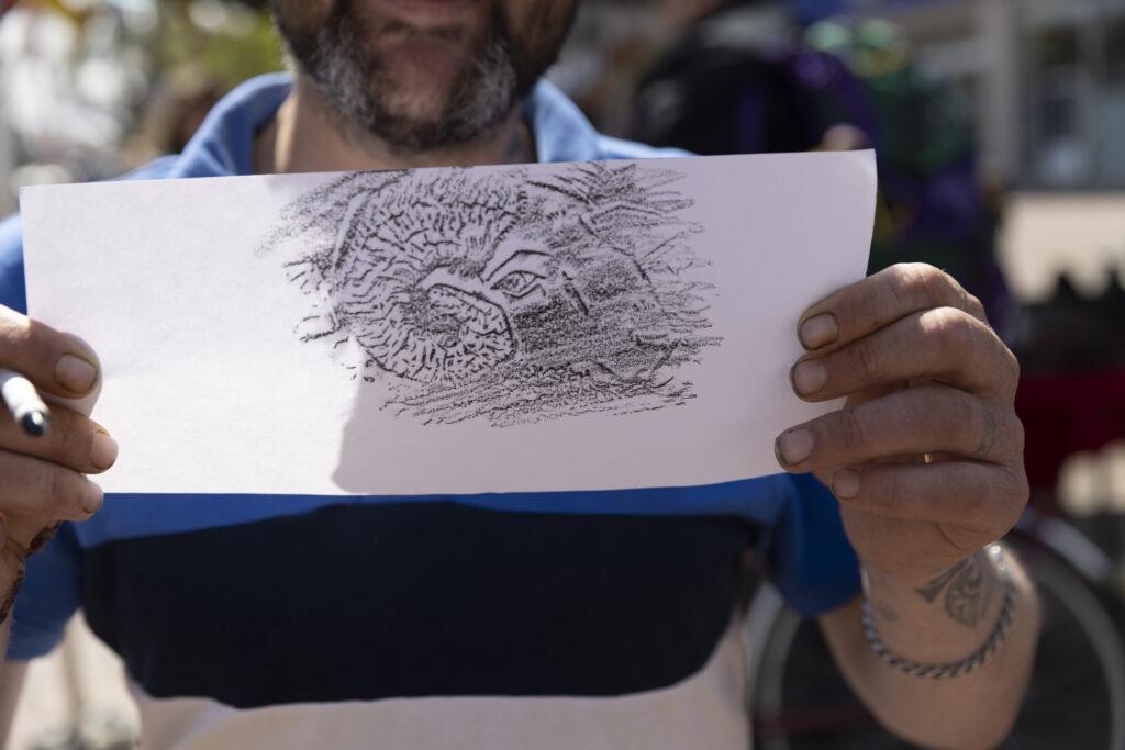 A man holds up a brass rubbing activity