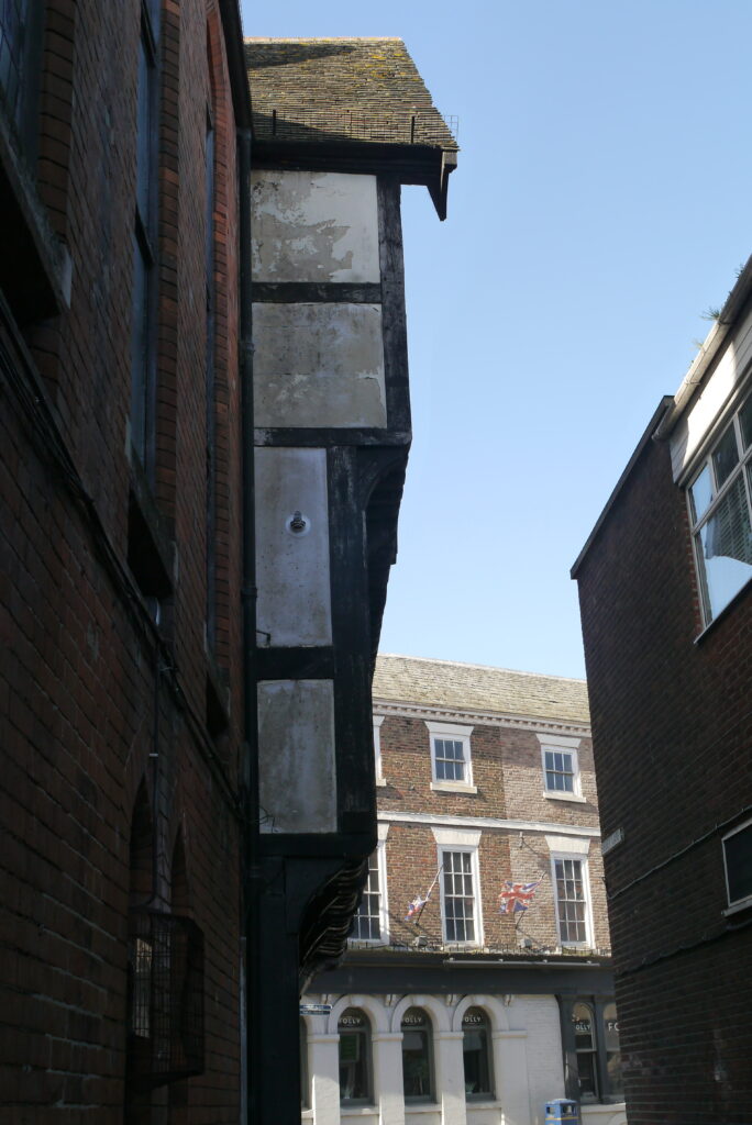Low angle mid shot image of overhanging tuder-esque window of Shodfriars Hall, taken from Shodfriars Lane