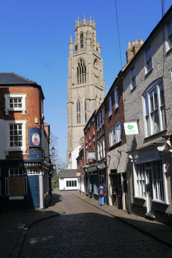 Wide shot of the side of wobbly historic Tudor house, Church House with St Botolphs seen beyond in Boston