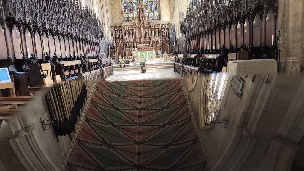A picture of the interior of St Botolphs, focused on a mirror showing the colourful ceiling