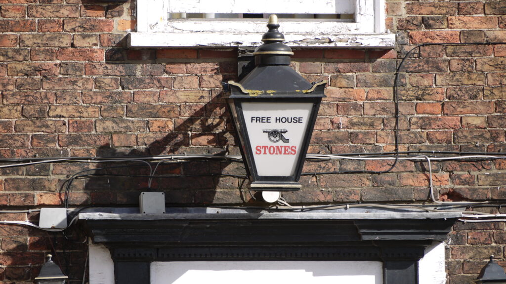 An old oil lamp above a doorway in Boston, converted to say 'Freehouse' inside