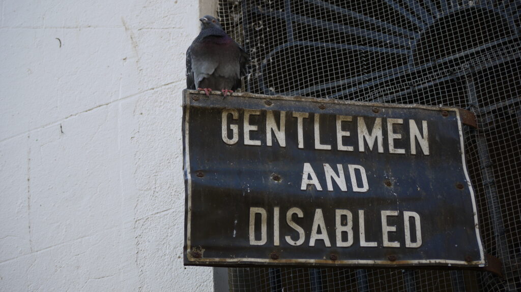 Sign on a building in Boston stating 'Gentleman and Disabled'