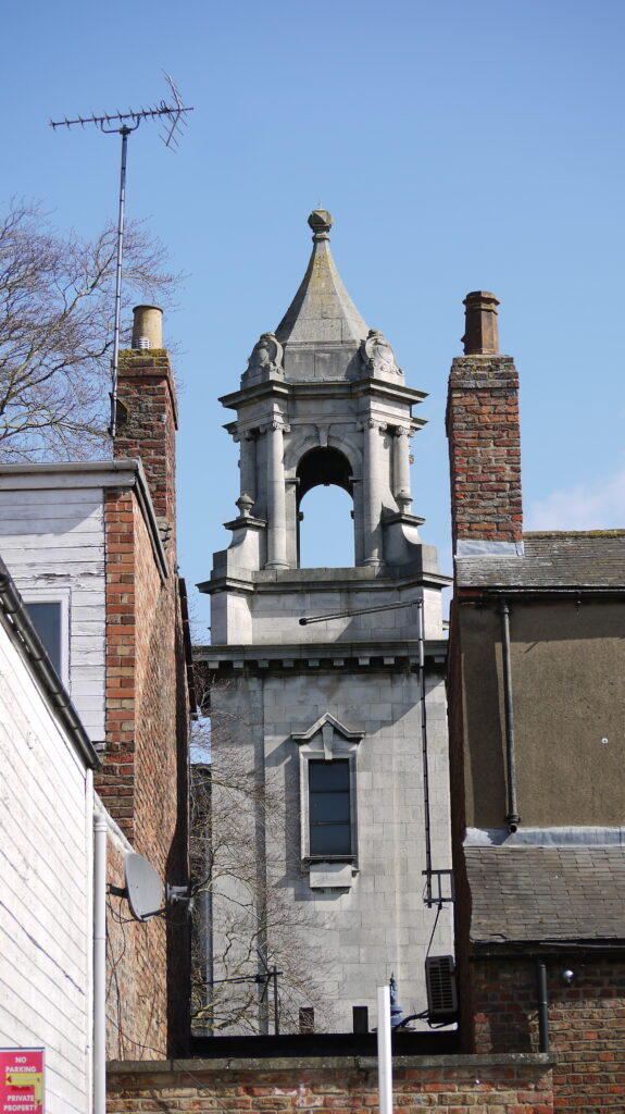 Image of an intricate grey stone-carved church bell tower in Boston