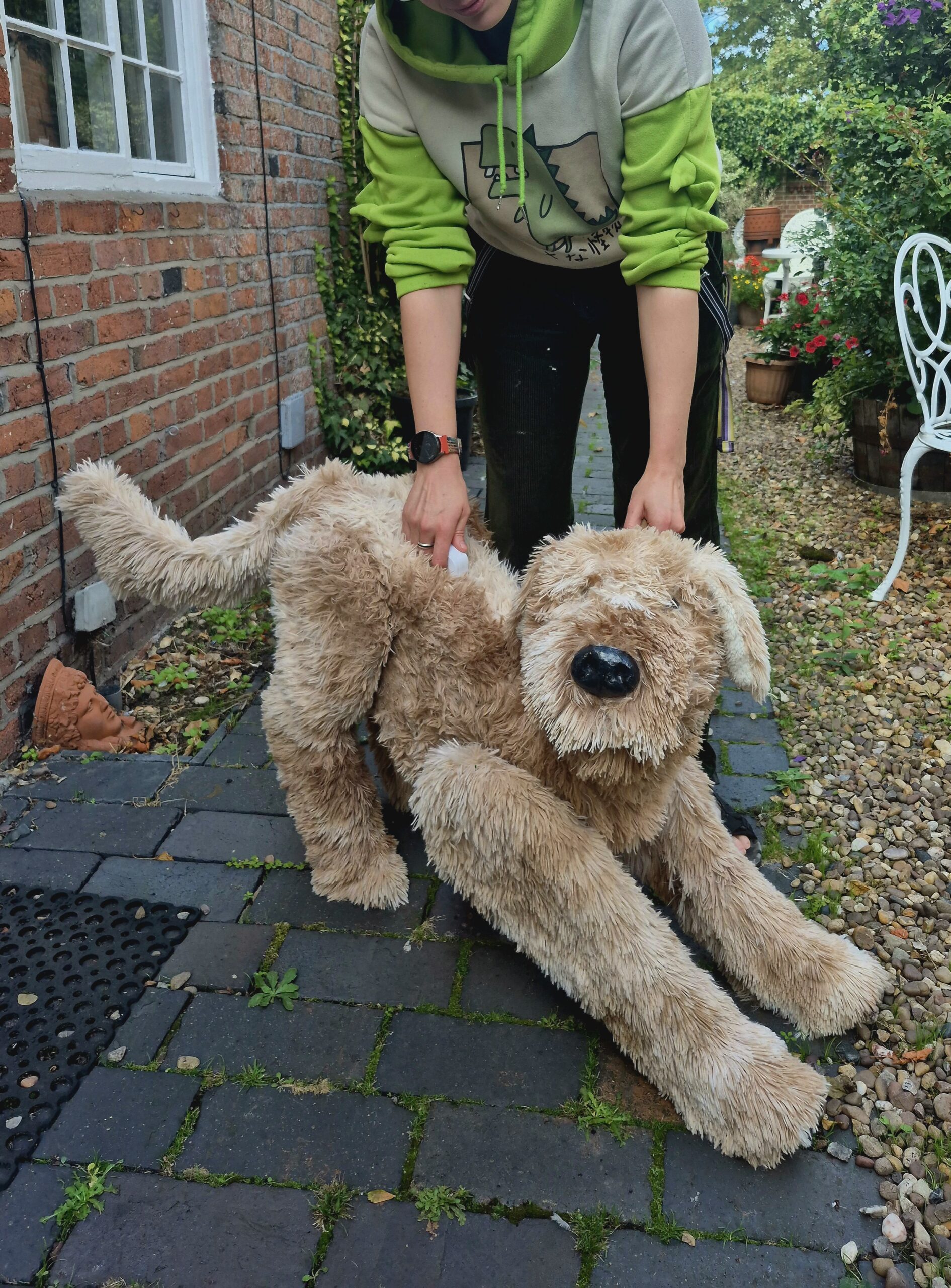 Puppeteer Robbie Bellekom demonstrates their handmade sandy-coloured dog puppet stretching