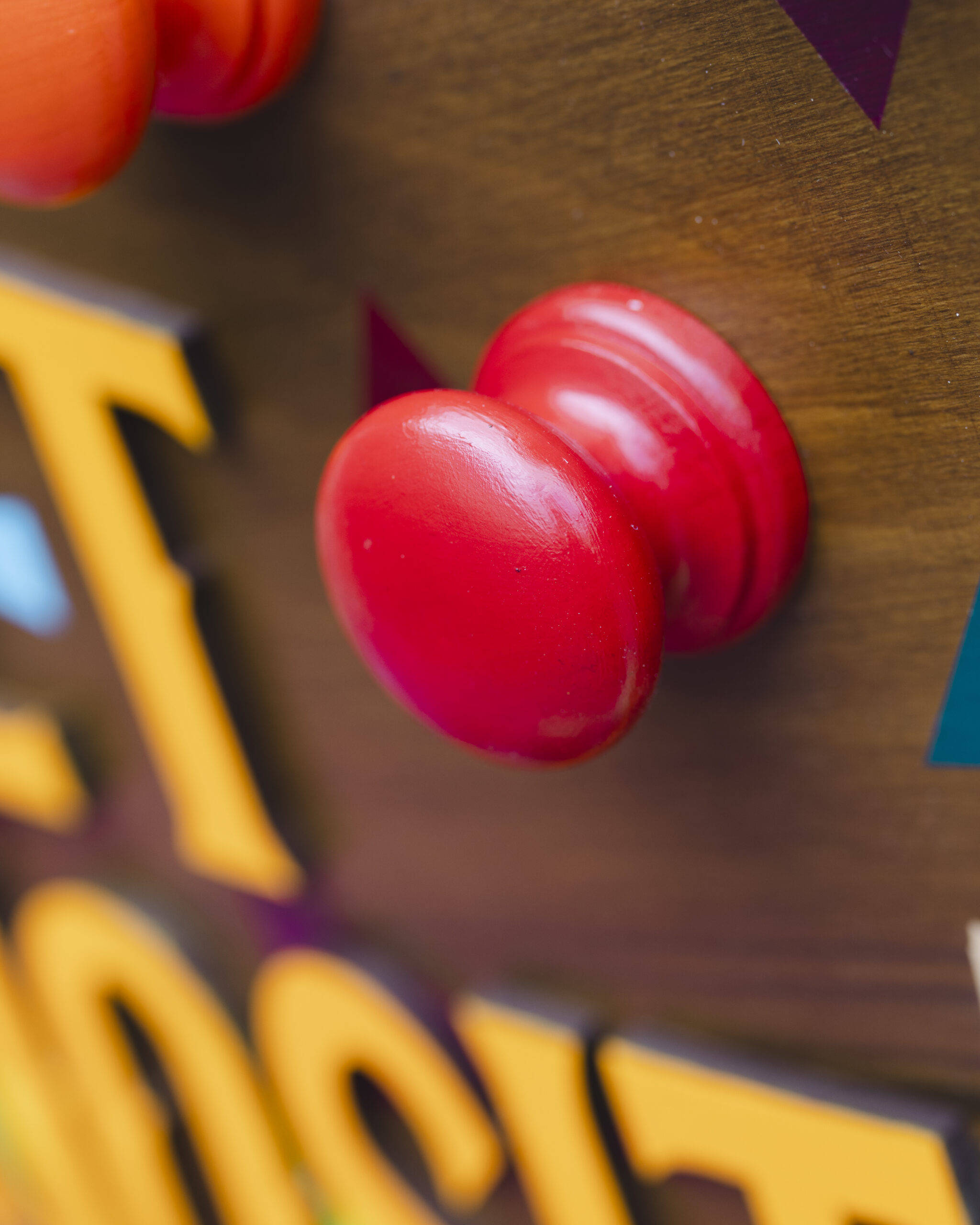 A close up image of a bright red handle on the Cabinet of Curiosities