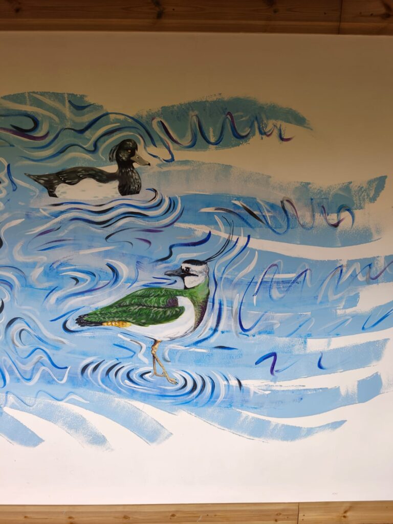 Detail of the Flyways Mural depicting coastal and wetland birds swimming and flying through swirling blue water.