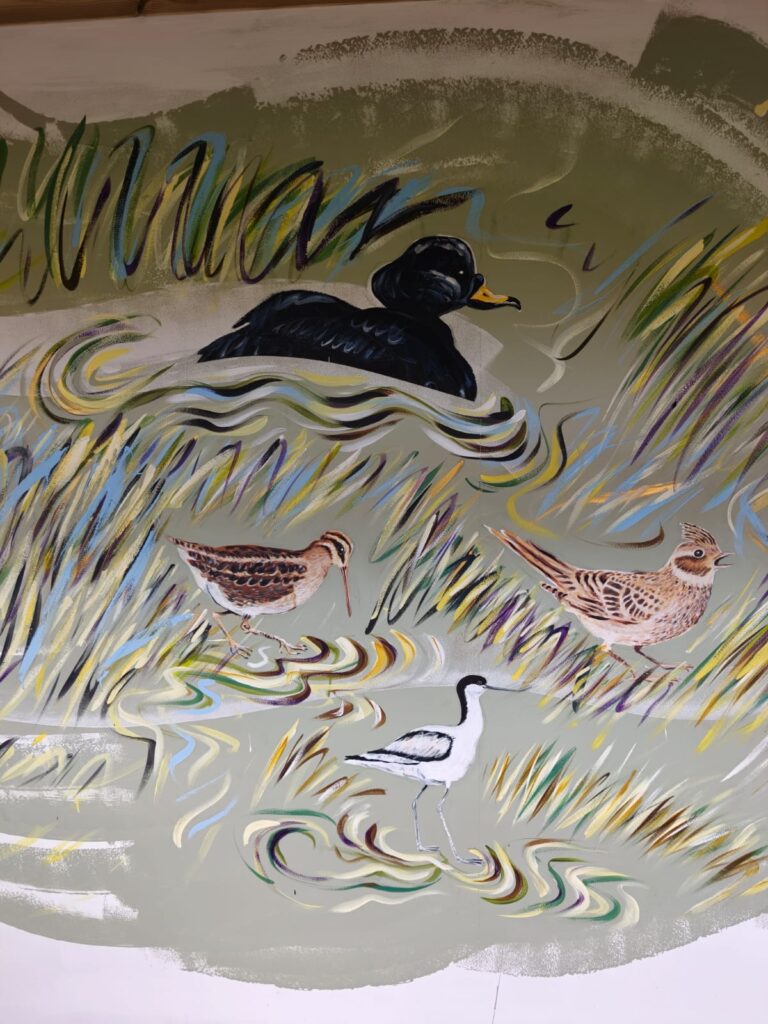 Detail of the Flyways Mural showing wetland birds among reeds and water at RSPB Freiston Shore.
